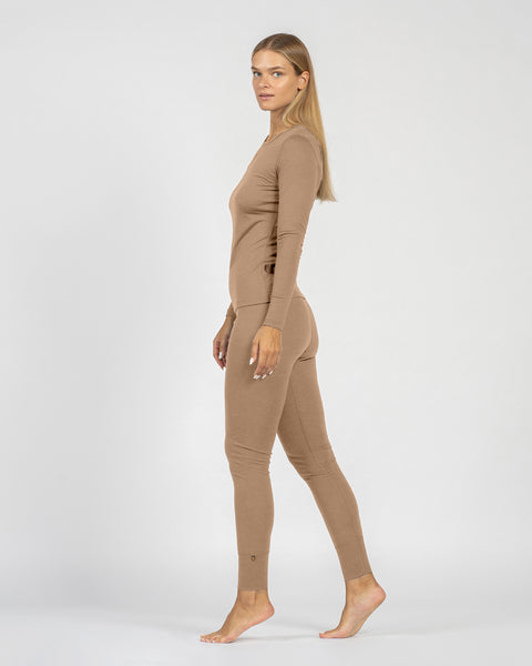 Mujer vistiendo un body beige sobre un fondo blanco