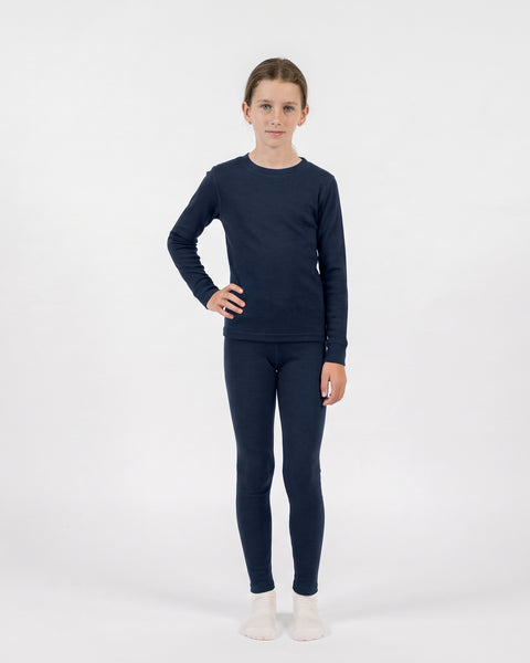A young girl modeling a matching two-piece set consisting of a long-sleeved navy blue thermal top and leggings.