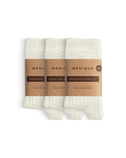 Un paquete de 3 pares de calcetines para niños de lana merina natural con etiquetas de “Calidad Premium Menique”.