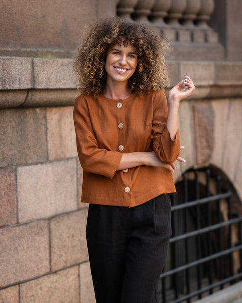 Mujer con cabello rizado vistiendo chaqueta de lino color Almendra Marrón Alice