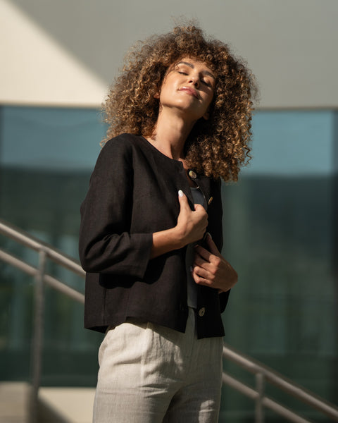 Mujer con cabello rizado vistiendo chaqueta negra de lino Alice