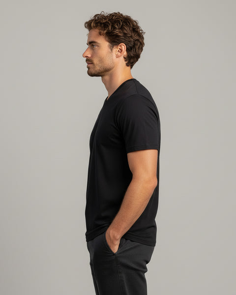 Hombre vistiendo una camiseta negra sobre un fondo gris