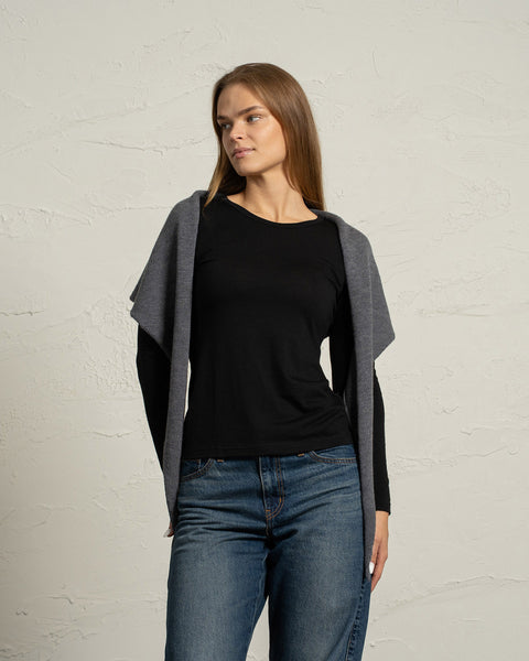 Bandana de punto de merino gris oscuro usada como bufanda con capucha por una mujer.