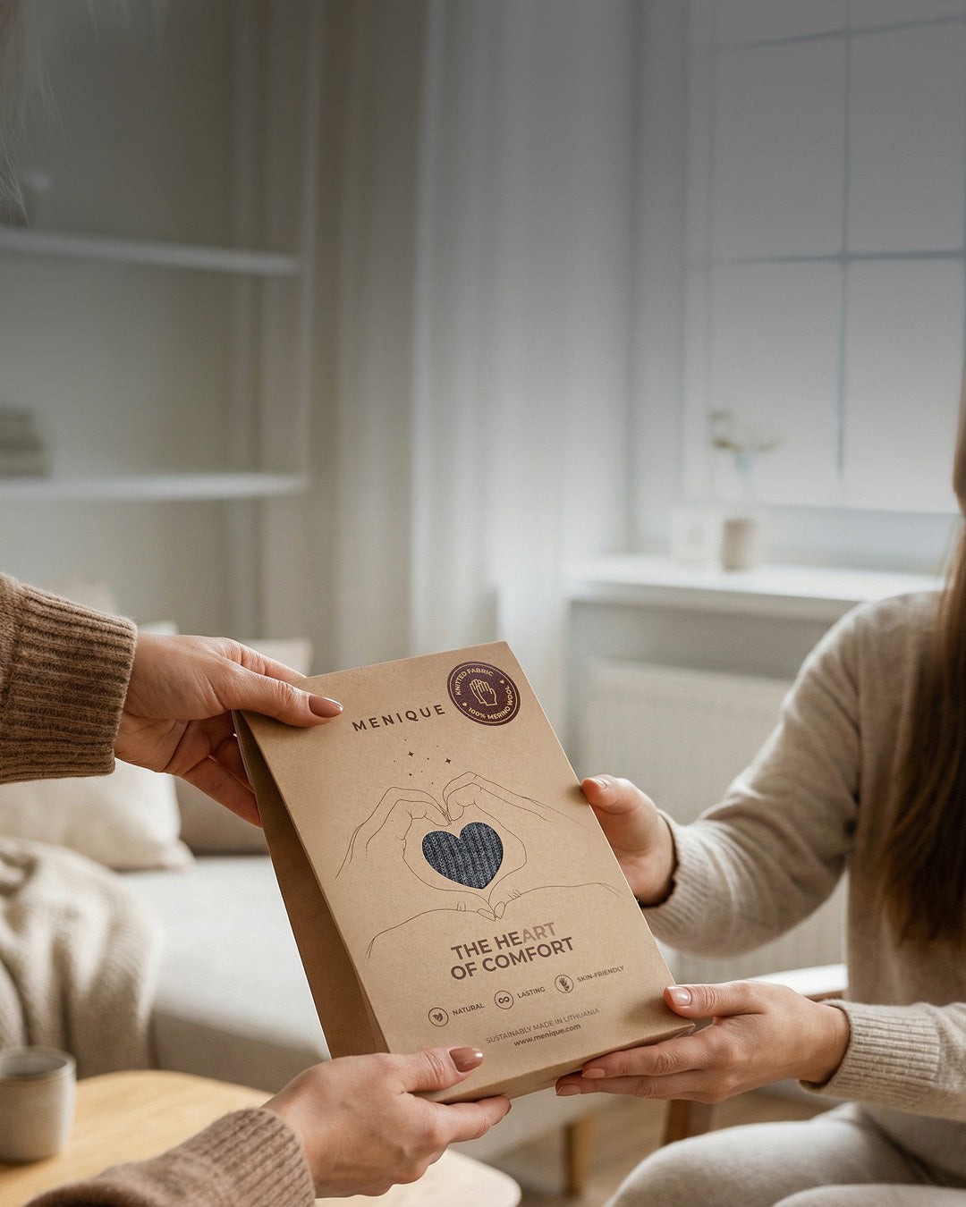 Dos personas sosteniendo un paquete marrón con la marca 'El Corazón del Confort' en una cocina.