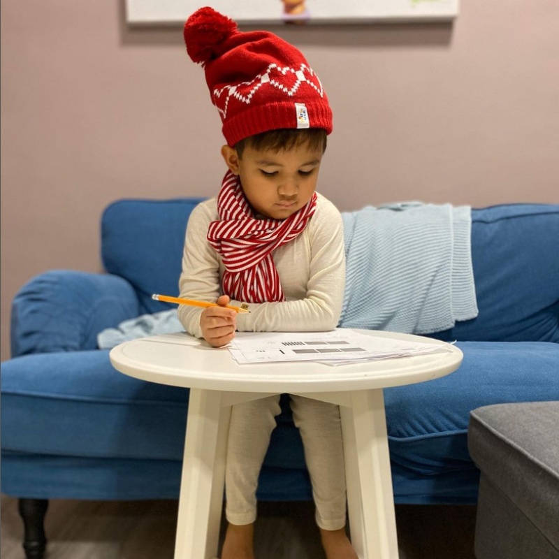 Un niño vistiendo capas base de lana merina en color natural.