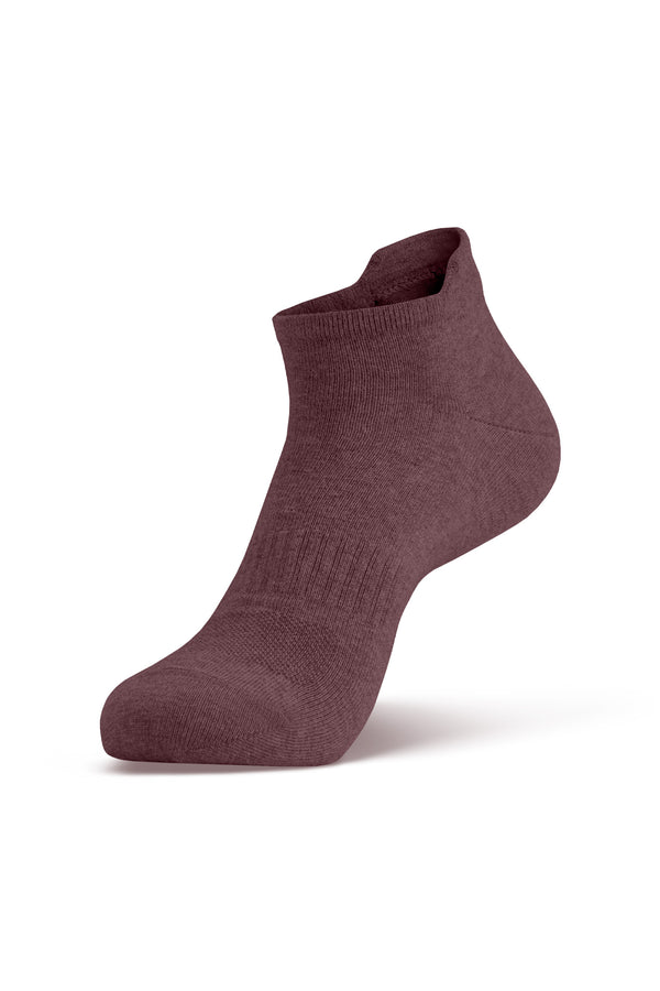 A single dark pink ankle sock shown on a foot model, angled to display the side profile and the top opening.