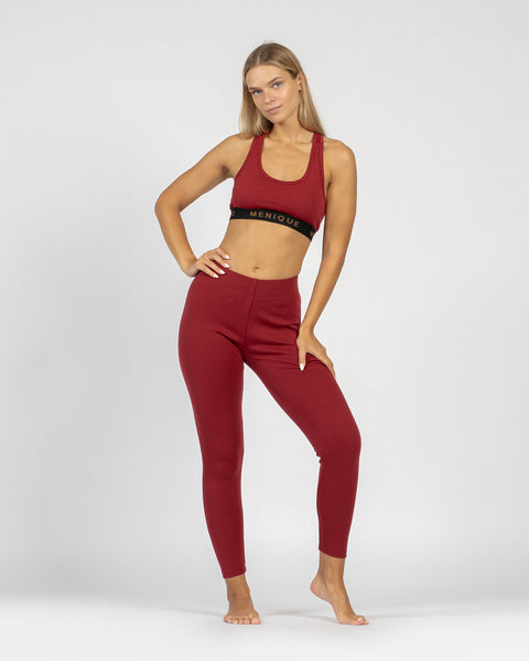 El sujetador deportivo para mujer de menique en lana merina de 160 g/m² y los leggings en tejido de 250 g/m², color cereza real.