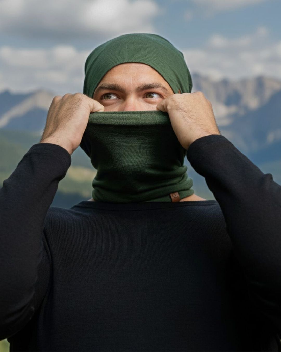 Persona con un pañuelo verde en la cabeza y pasamontañas con montañas al fondo