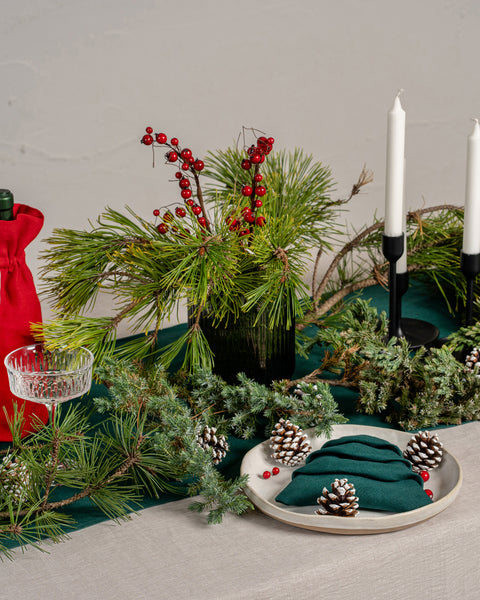 El mantel de lino menique en color natural. El mantel cubre una mesa de madera