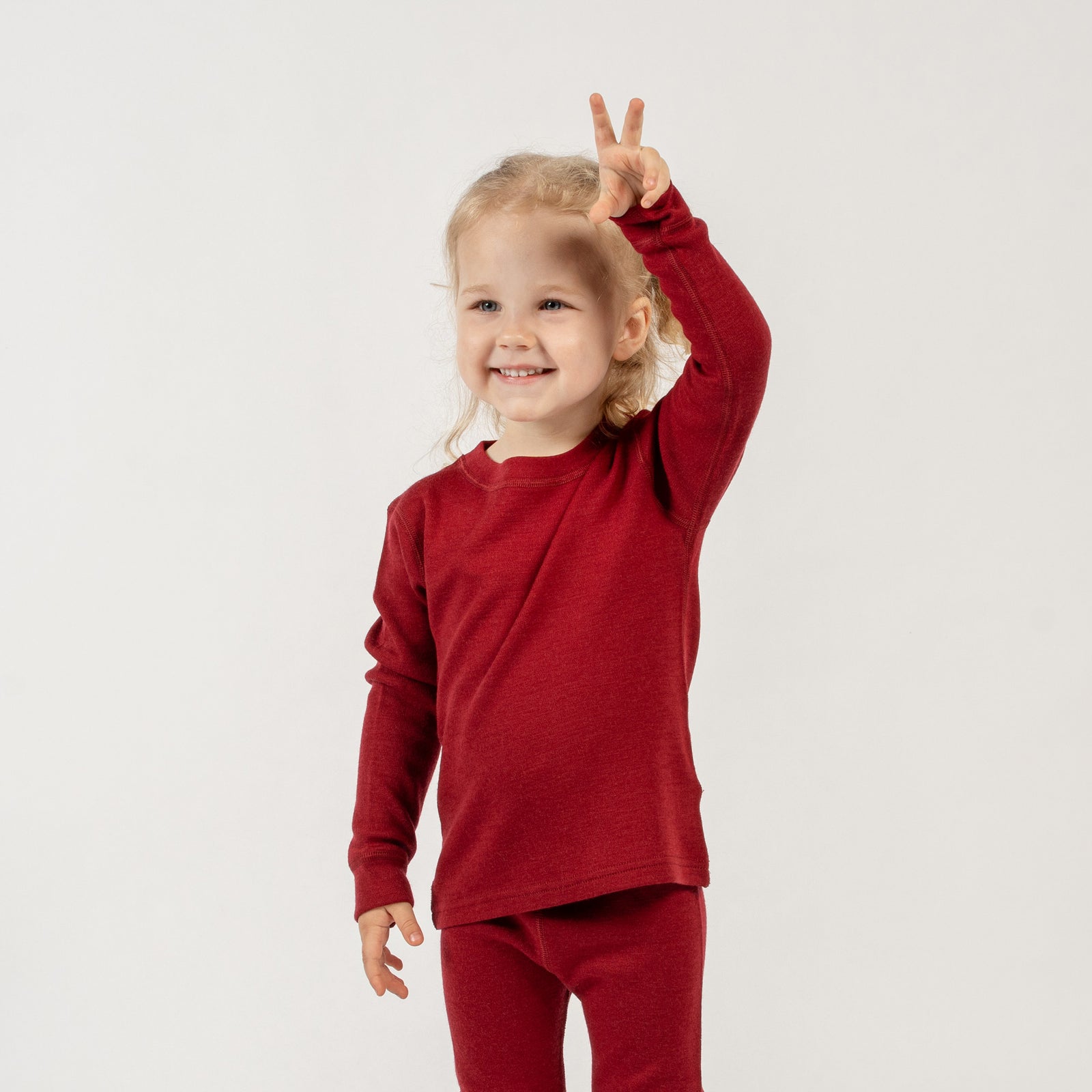 Vista frontal de la camiseta de manga larga para niños menique merino 250gsm, en color cereza real, fondo blanco.