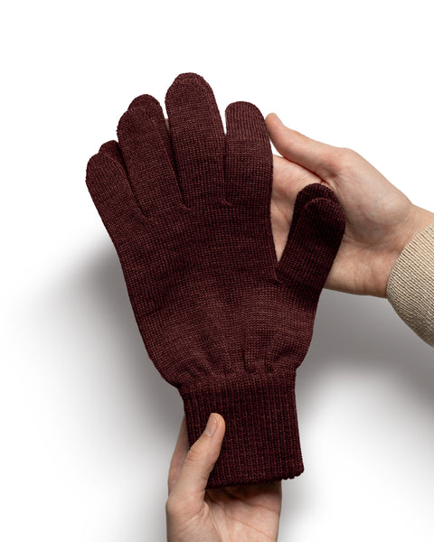 Royal cherry Merino wool knit glove held in hands highlighting softness and detailed stitching.