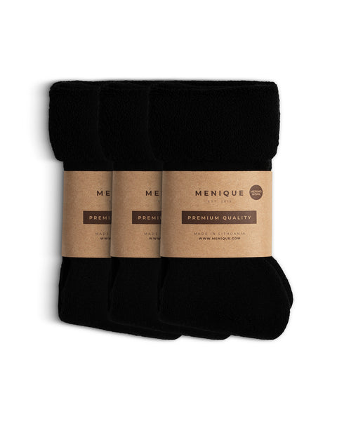 Juego de tres pares de calcetines negros para hombre de forro polar sherpa, enrollados y envueltos con embalaje de papel marrón de Menique etiquetado como ‘Calidad Premium – Lana Merina’.