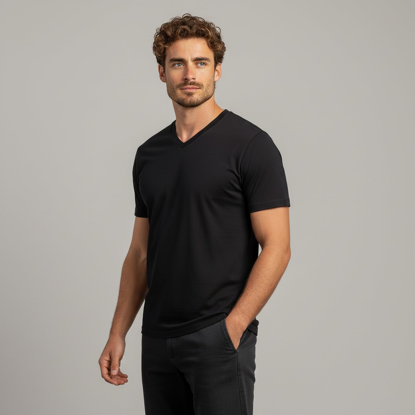 Man wearing a blue V-neck t-shirt against a gray background