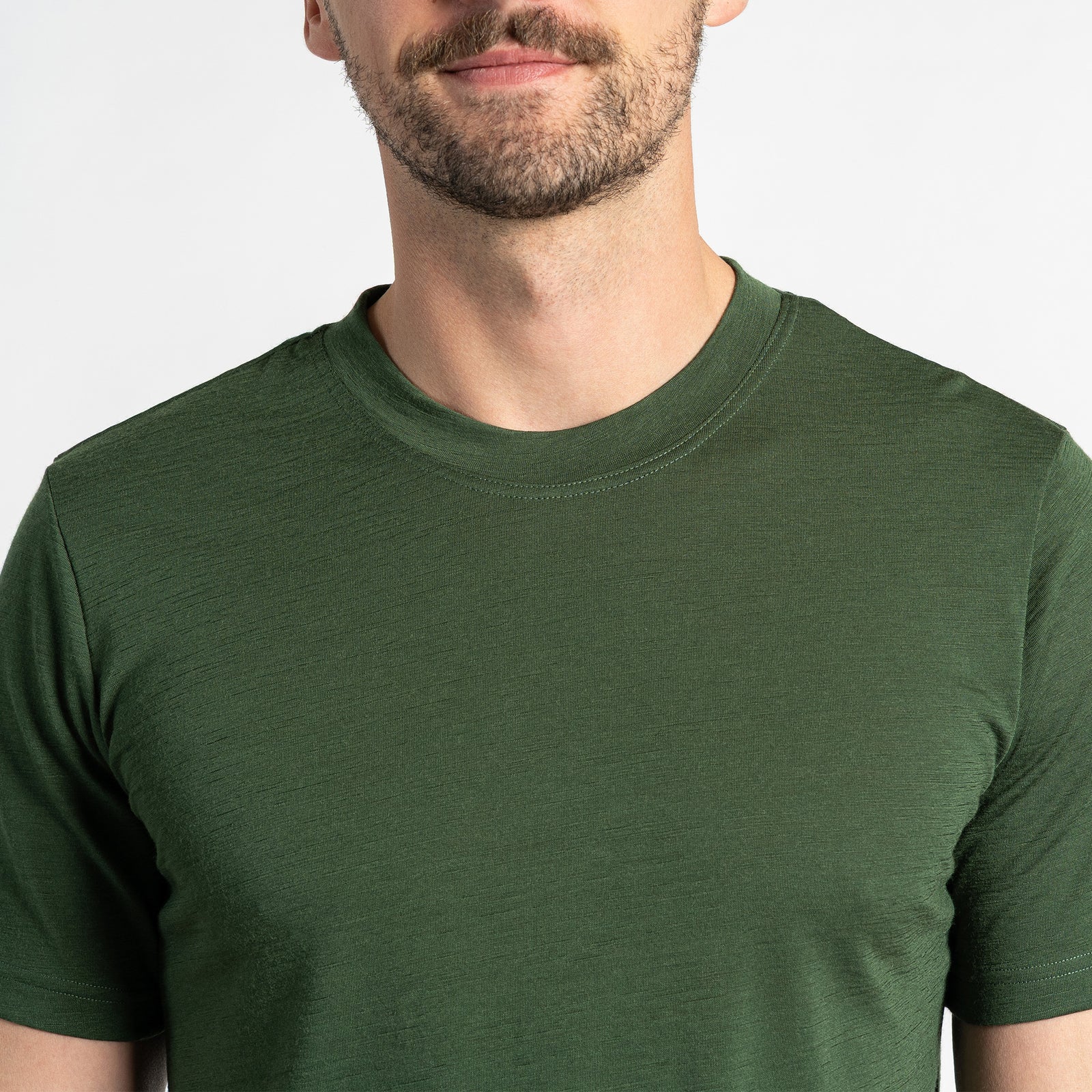 Dos camisetas de manga corta para hombre en verde oscuro, hechas de lana merina, transpirables y resistentes al olor, diseñadas para ofrecer comodidad y versatilidad.