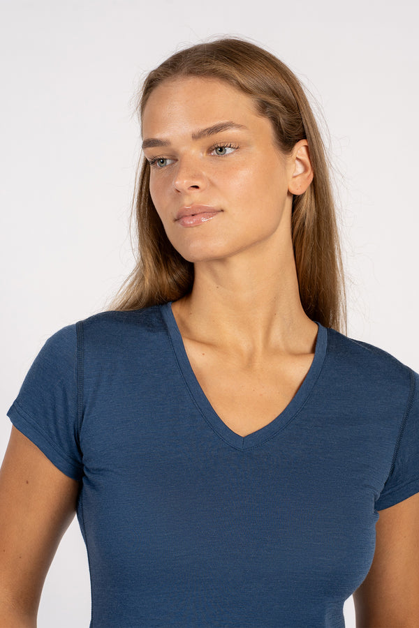 Primer plano de una mujer que lleva una camiseta de manga corta con cuello en V de lana merina y mezclilla.