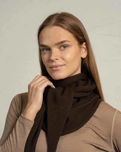 Primer plano de un pañuelo de punto marrón de merino envuelto alrededor del cuello.